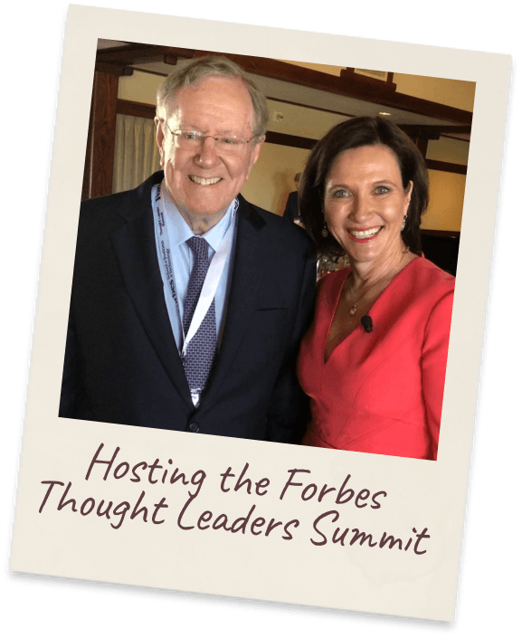 Hosting the Forbes Thought Leaders Summit. Margie in a red jacket beside Steve Forbes at a conference.