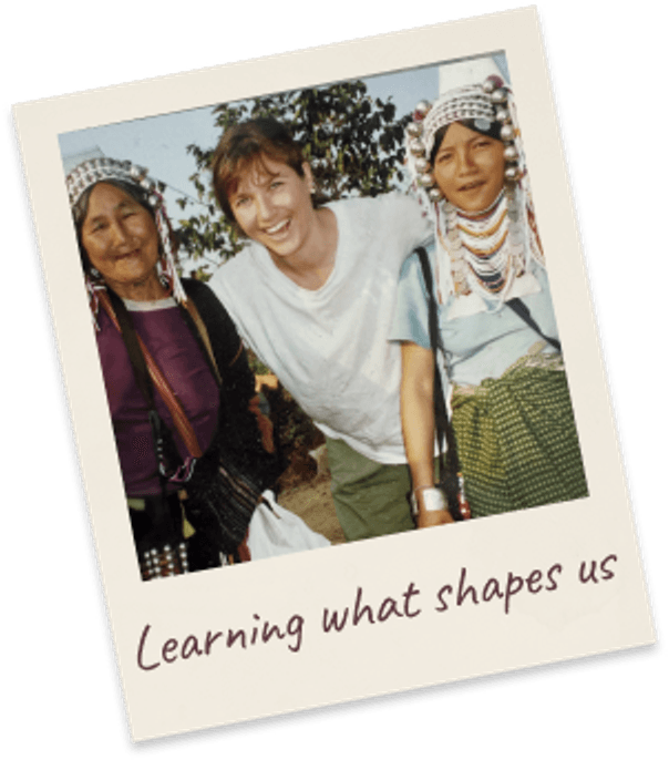Learning what shapes us. Margie standing between two hill-tribe women in traditional beaded headdresses and embroidered dress.
