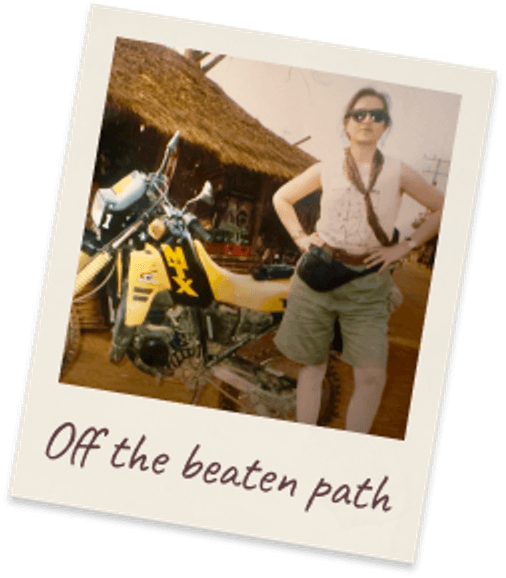 Off the beaten path. Margie in shorts and sunglasses beside a yellow motorbike outside a thatched hut, Thailand 1991.