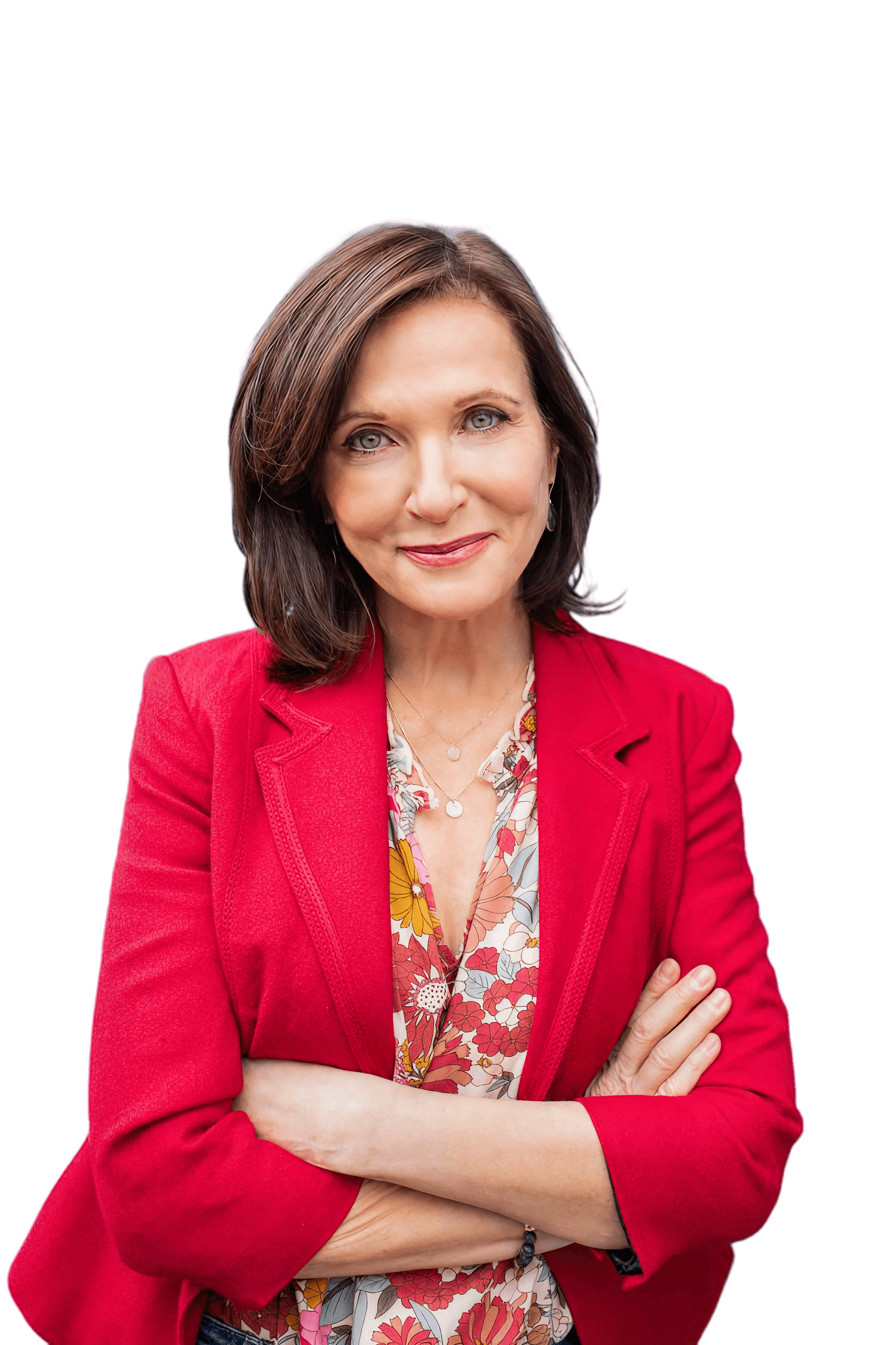 Margie Warrell standing with her arms folded, smiling to camera in a bright red blazer over a floral blouse